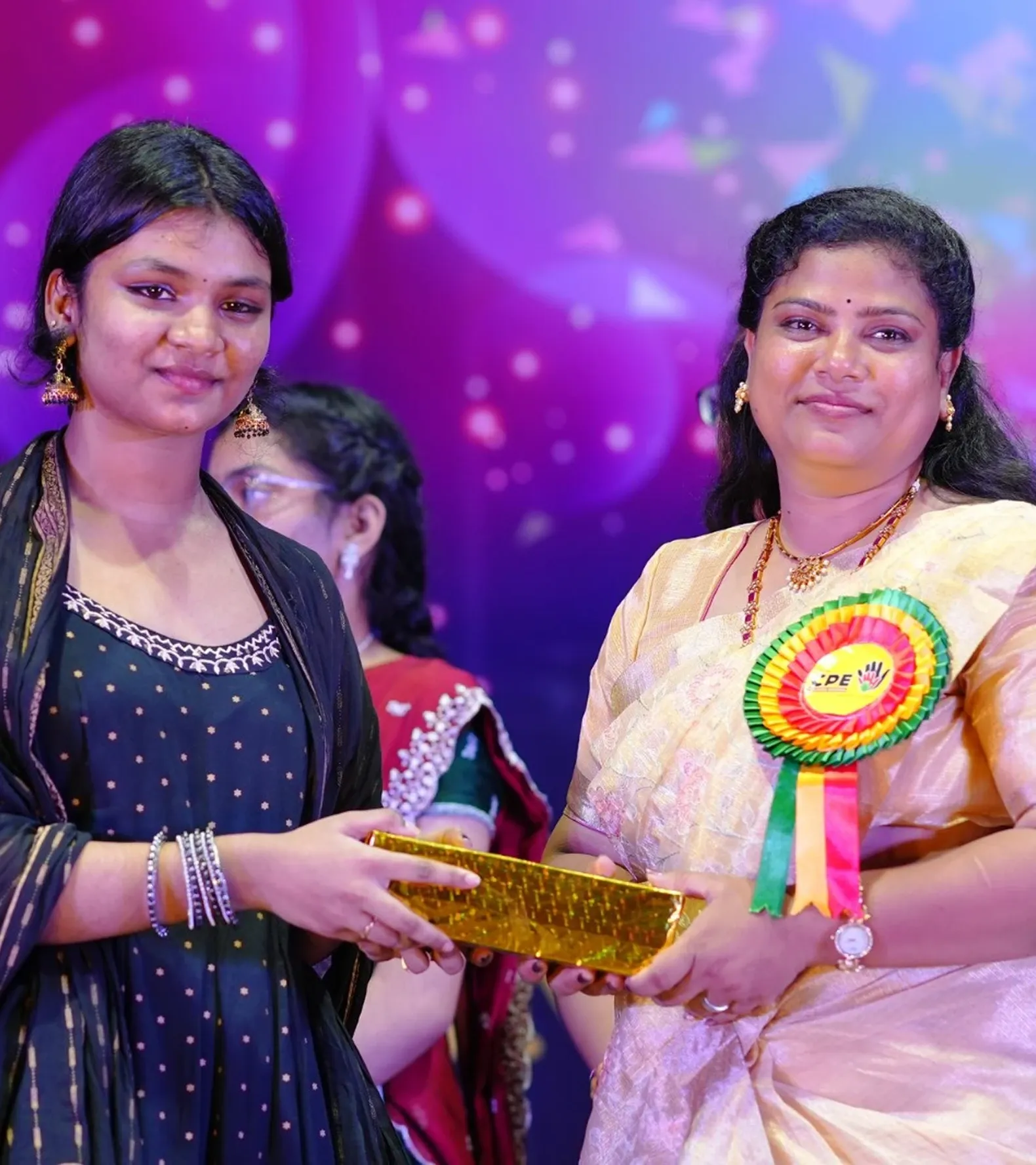 A student receiving a gift from a faculty member